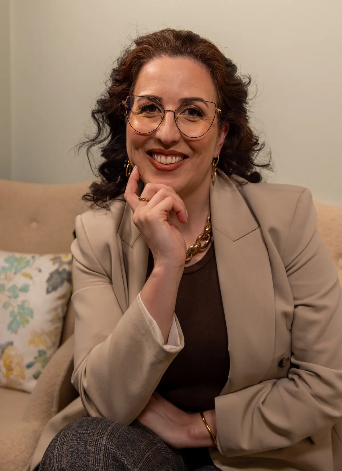 Fernanda Rosa, terapeuta, sorridente, sentada no seu espaço de atendimento